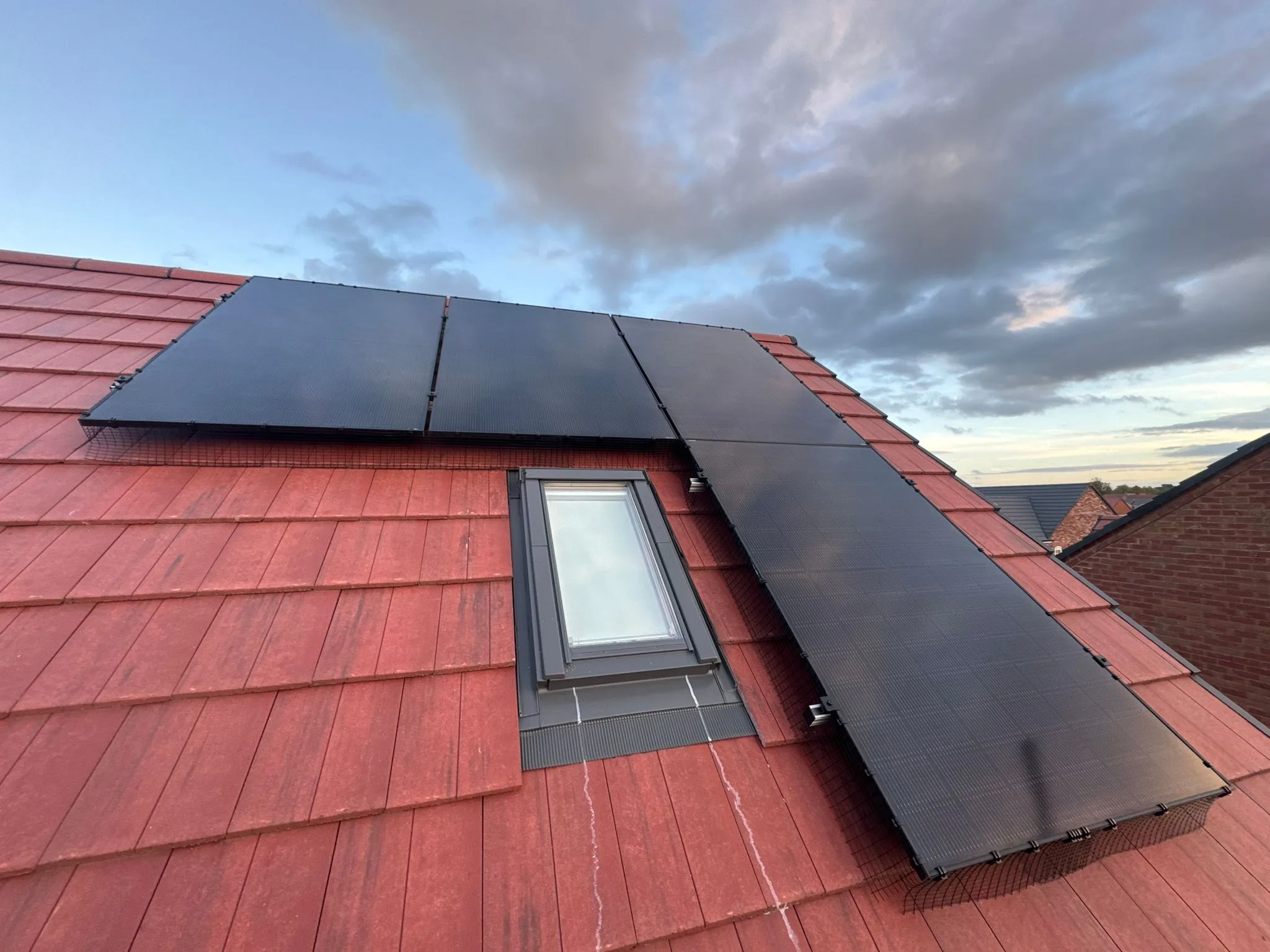 Solar panels on red tile roof, representing Newcastle